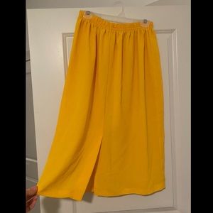 Comfy flowing midi skirt with elastic waistband and slit detail. Size M, yellow